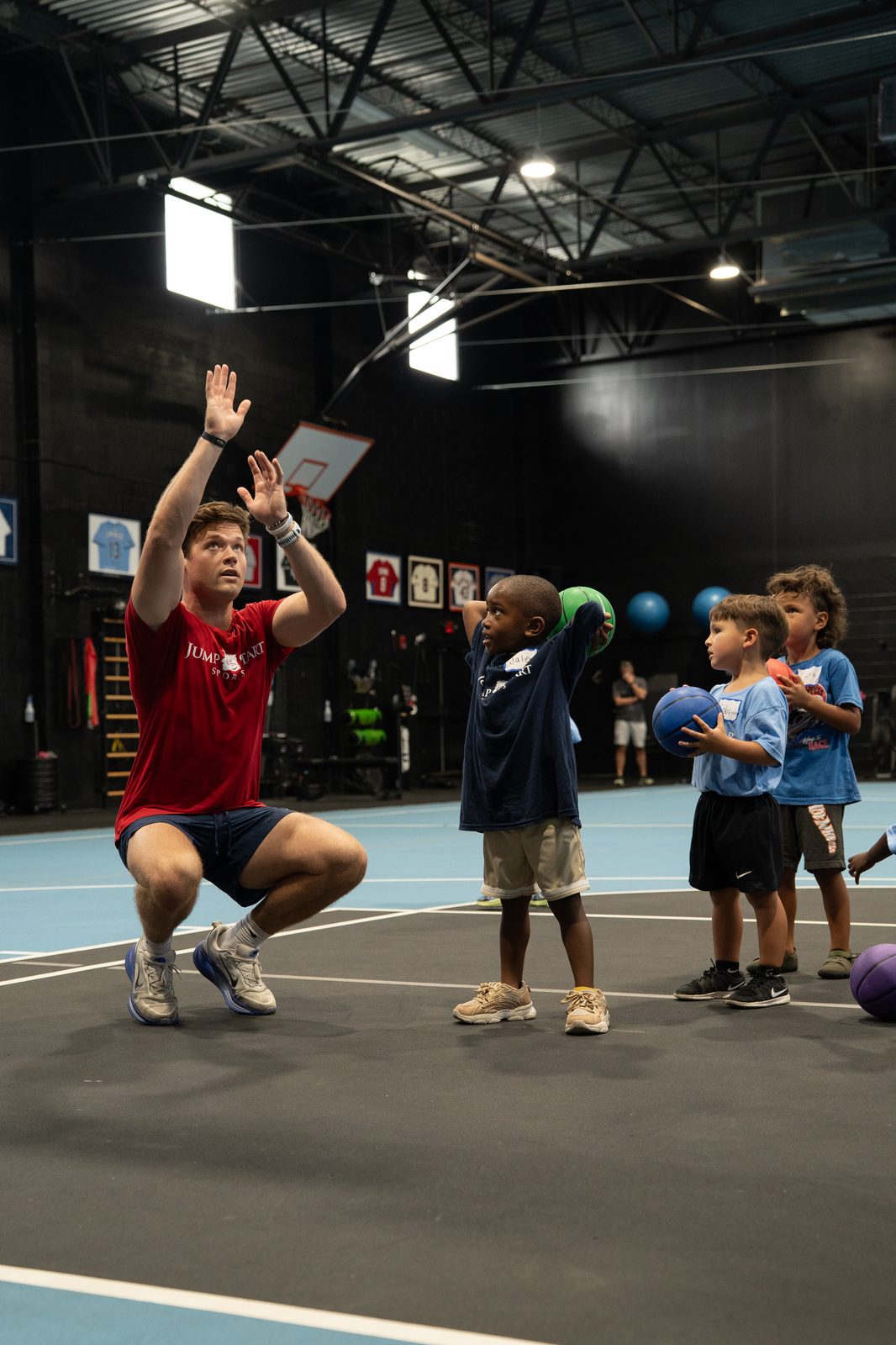 Coach working on basketball shooting form with a young player